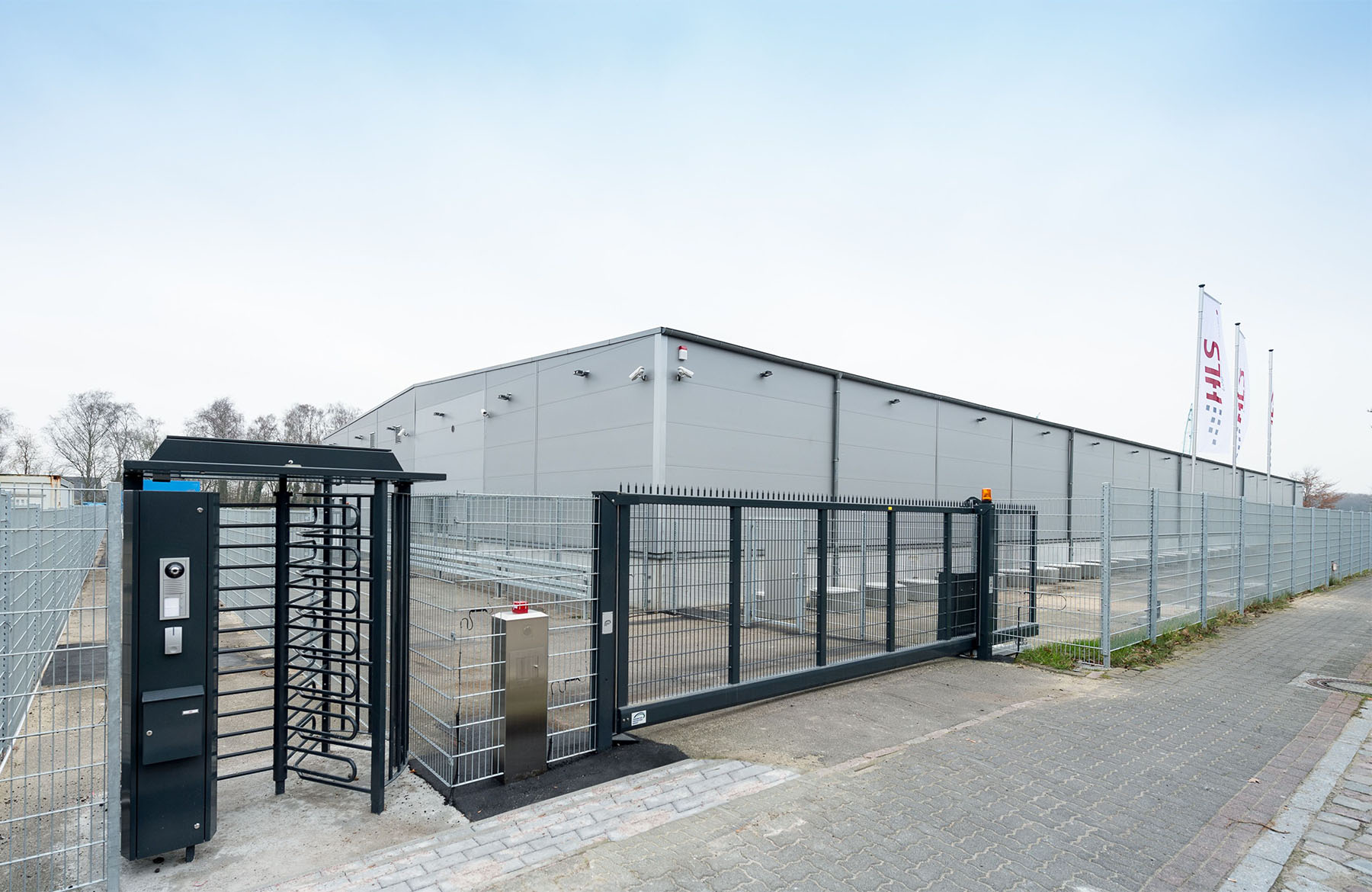 Gesicherter Zugang mit Drehkreuz und Überwachungskameras bei HLS