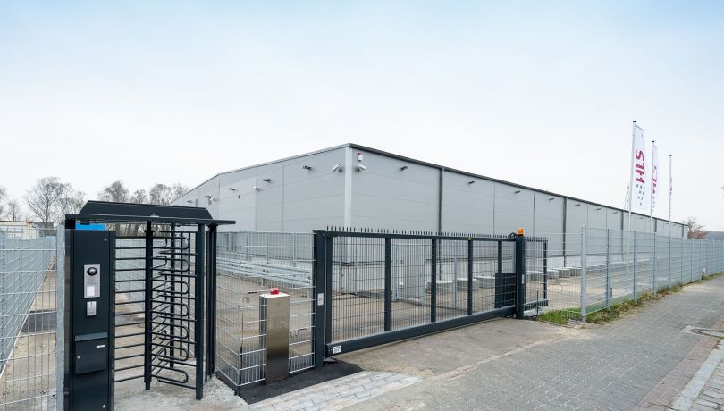 Gesicherter Zugang mit Drehkreuz und Überwachungskameras bei HLS